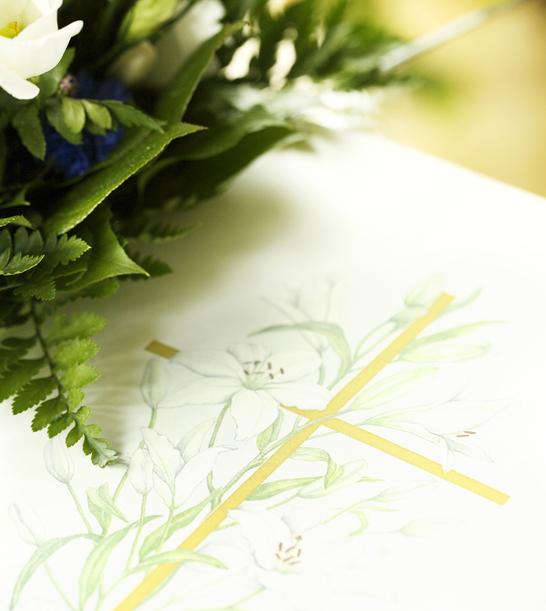 Detailansicht von weißen Blumen und grünem Blattwerk neben einer handgezeichneten Blumenillustration mit goldener Akzentlinie.